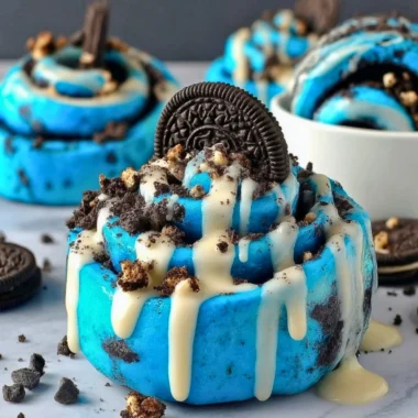 Delicious Cookie Monster cinnamon rolls with blue swirl topped with icing.