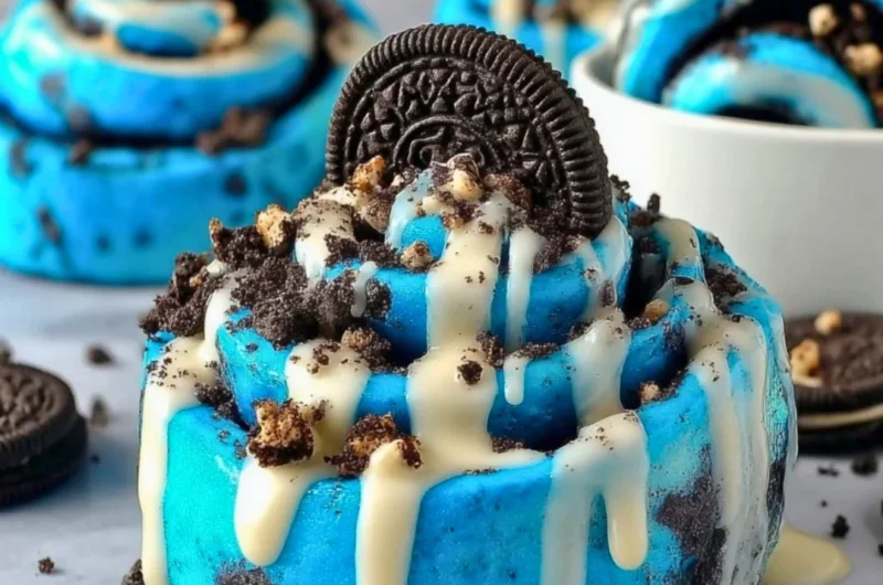 Delicious Cookie Monster cinnamon rolls with blue swirl topped with icing.