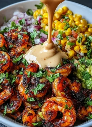 Colorful grilled shrimp bowl with avocado, corn salsa, and creamy garlic sauce