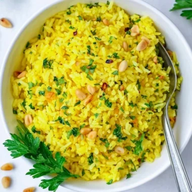 Bowl of Mediterranean yellow rice garnished with herbs