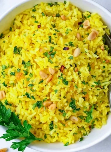 Bowl of Mediterranean yellow rice garnished with herbs