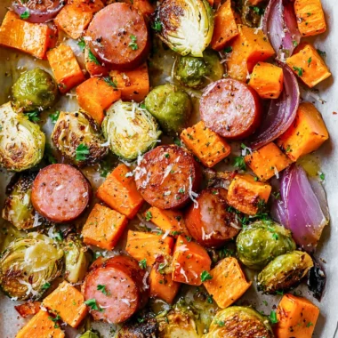 Sheet-pan sausage with fall vegetables ready to serve on a plate.