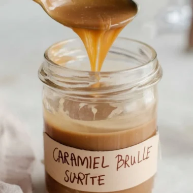 Caramel Brulee Latte syrup bottle on a wooden table with coffee cup