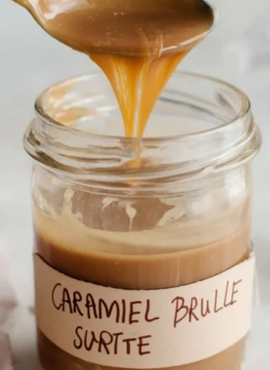 Caramel Brulee Latte syrup bottle on a wooden table with coffee cup