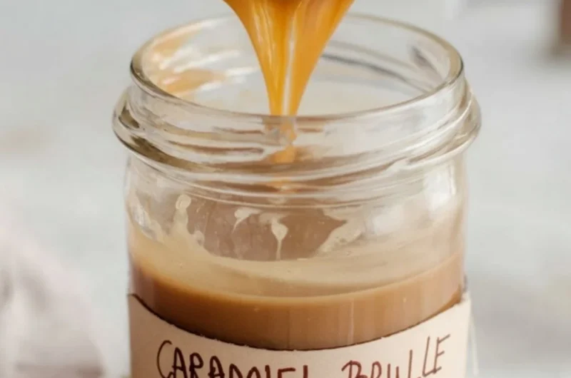 Caramel Brulee Latte syrup bottle on a wooden table with coffee cup