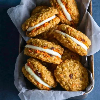 An assortment of carrot cake cookies with frosting on top, showcasing the delicious treat.