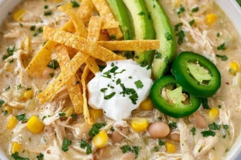 Creamy white chicken chili in a bowl with toppings, showcasing its delicious texture.