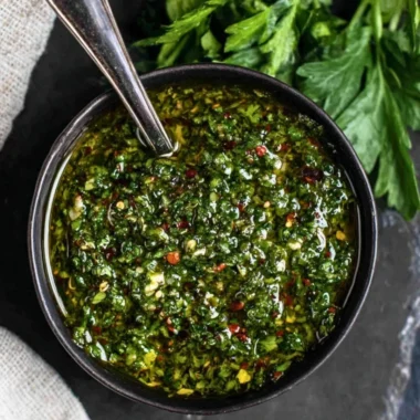 Fresh chimichurri sauce in a small bowl with herbs and garlic