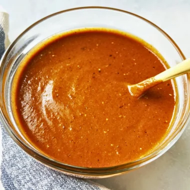 Homemade enchilada sauce in a bowl with fresh ingredients