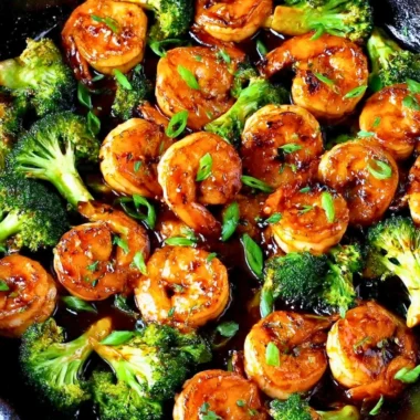 Close-up of Honey Garlic Butter Shrimp on a plate with garnishes.