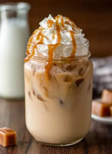 Delicious iced caramel latte topped with whipped cream and caramel drizzle