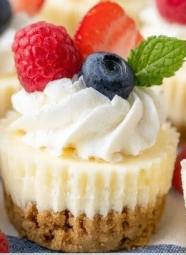 Delicious mini cheesecakes topped with fresh fruit on a white plate