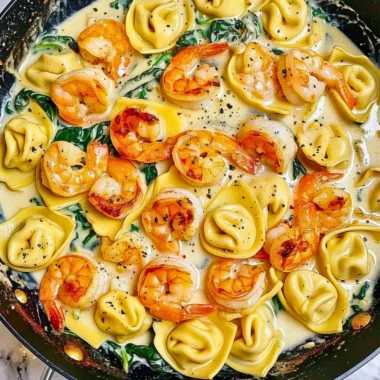 Plate of shrimp tortellini topped with garlic sauce and herbs