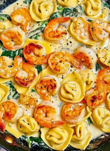 Plate of shrimp tortellini topped with garlic sauce and herbs