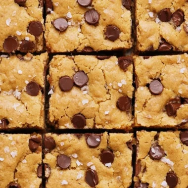 Delicious ultra flavorful blondies dessert topped with chocolate chips and nuts