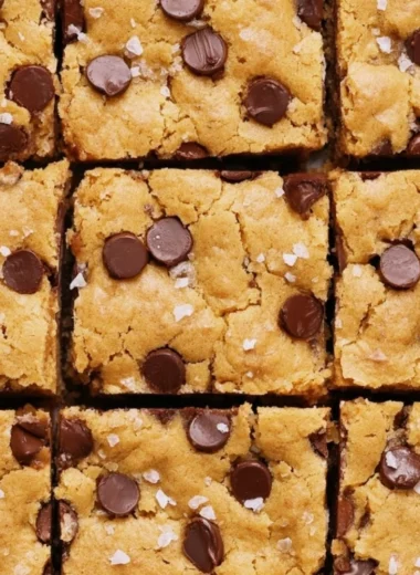 Delicious ultra flavorful blondies dessert topped with chocolate chips and nuts