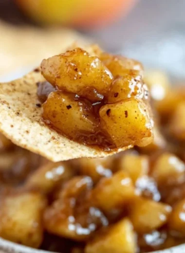 Delicious apple pie dip served in a bowl with apple slices and caramel sauce