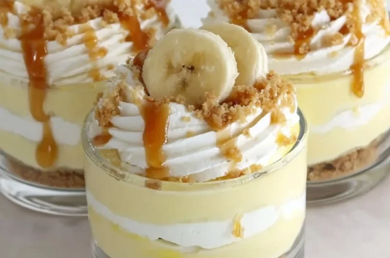 Delicious Banana Caramel Cream Dessert in a glass, topped with whipped cream and banana slices.