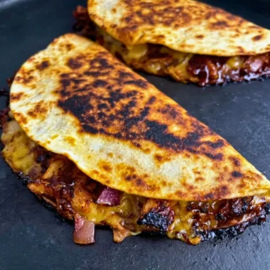 Deliciously grilled Blackstone Hot Honey BBQ Chicken Quesadillas filled with melted cheese