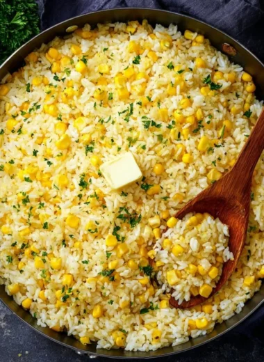 Plate of buttered corn rice with fresh herbs and golden corn kernels