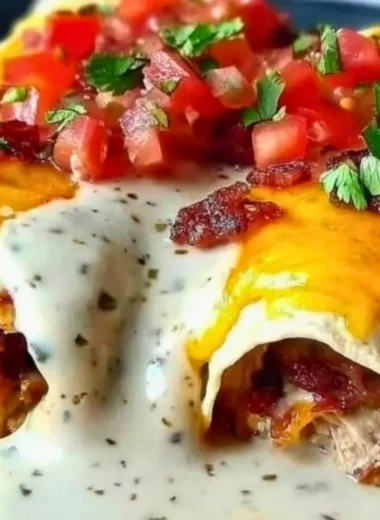 Plate of Jalapeño Popper Cheesy Chicken Enchiladas topped with cheese and jalapeños