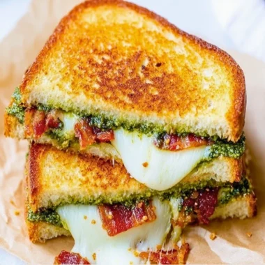 Delicious pesto grilled cheese sandwich with melted cheese and fresh basil