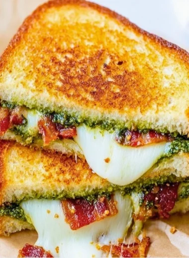 Delicious pesto grilled cheese sandwich with melted cheese and fresh basil
