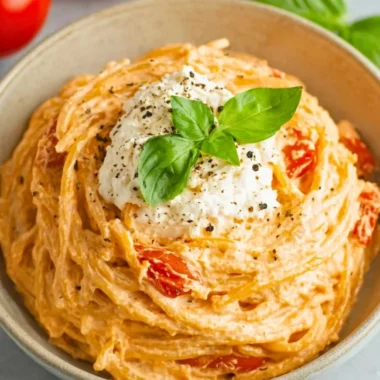 Bowl of roasted tomato garlic ricotta pasta with fresh herbs