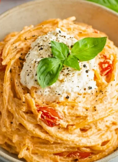 Bowl of roasted tomato garlic ricotta pasta with fresh herbs