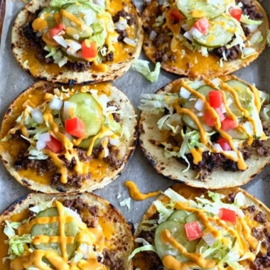 Smashed cheeseburger tacos served with toppings on a plate