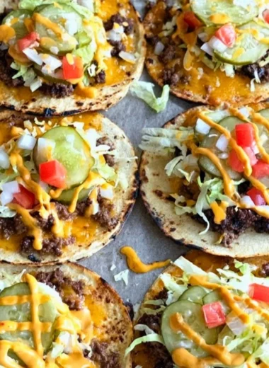 Smashed cheeseburger tacos served with toppings on a plate
