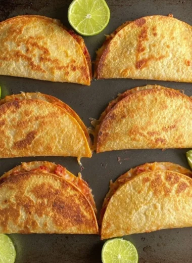 Freshly baked chicken tacos topped with cheese and salsa
