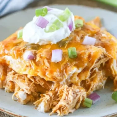 Delicious Chicken Enchilada Casserole topped with cheese and jalapeños
