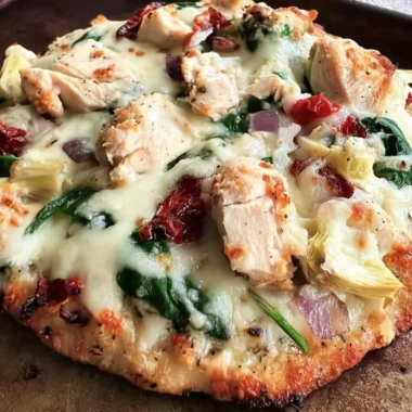 Delicious Chicken Spinach Artichoke Pizza topped with fresh vegetables and chicken