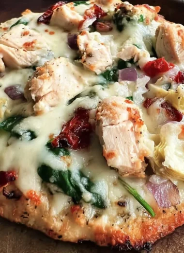 Delicious Chicken Spinach Artichoke Pizza topped with fresh vegetables and chicken