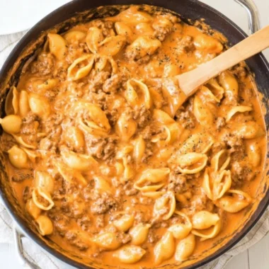 Creamy beef and shells dish served in a bowl with herbs on top