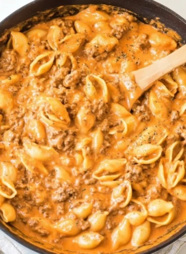 Creamy beef and shells dish served in a bowl with herbs on top