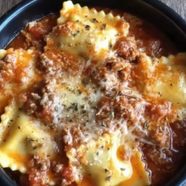 Crockpot Ravioli Lasagna served with fresh herbs and melted cheese
