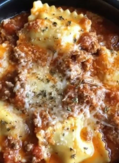 Crockpot Ravioli Lasagna served with fresh herbs and melted cheese