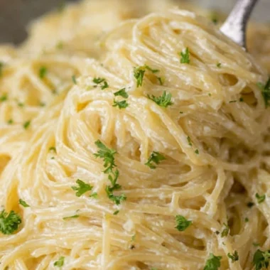 Delicious bowl of Garlic Parmesan Pasta topped with parsley and grated parmesan cheese.