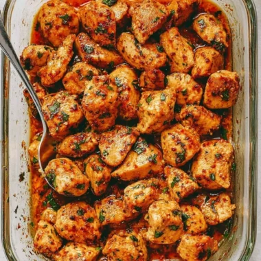 Plate of juicy oven baked chicken bites garnished with herbs