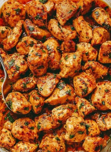 Plate of juicy oven baked chicken bites garnished with herbs