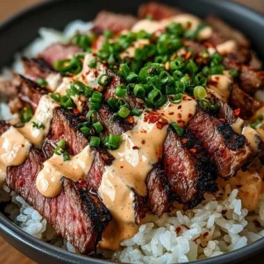 Korean BBQ steak rice bowl served with vegetables and sauce.
