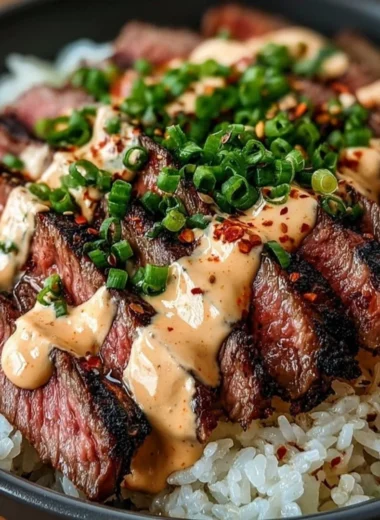 Korean BBQ steak rice bowl served with vegetables and sauce.