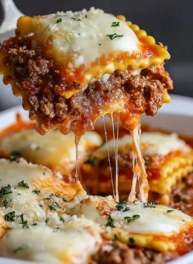 Delicious Million Dollar Ravioli Casserole topped with melted cheese and herbs