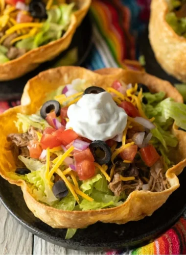 Colorful taco salad bowls filled with fresh ingredients and toppings.