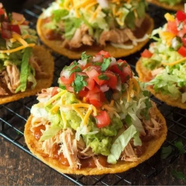 Delicious Chicken Tostadas with guacamole and beans served on a plate.