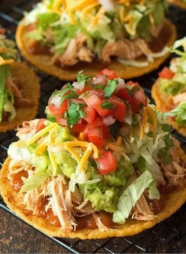 Delicious Chicken Tostadas with guacamole and beans served on a plate.