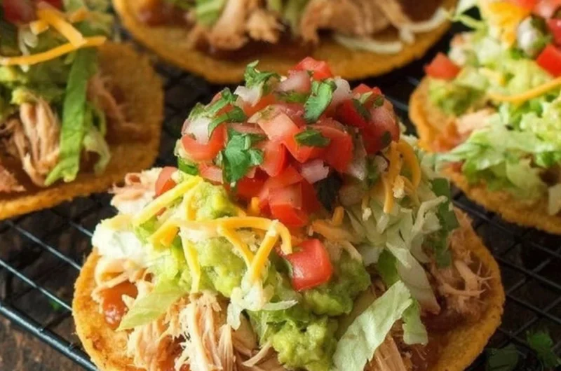 Delicious Chicken Tostadas with guacamole and beans served on a plate.