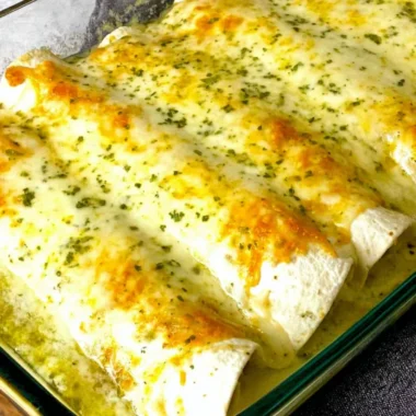 White chicken enchiladas topped with cheese and green sauce